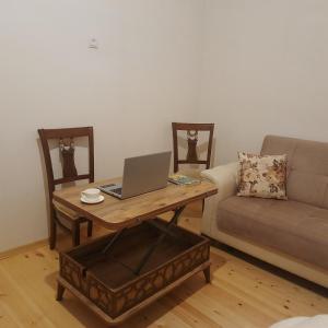 a living room with a couch and a table with a laptop at Sweet Home in Tbilisi City