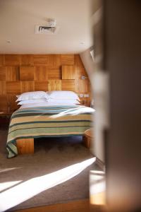 a bedroom with a bed with wooden walls at Drakes Hotel in Brighton & Hove