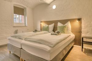 2 camas blancas grandes en una habitación con ventana en HOMY I Gewölbetraum Nähe Zentrum, en Halle an der Saale