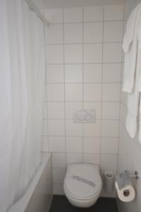 a white bathroom with a toilet and a sink at Loft in the historical center - Symbol 4 in Zürich