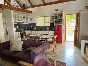 a living room with a couch and a table in a kitchen at Quince Cottage in Goedverwag