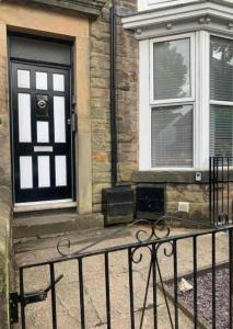 a black fence in front of a building with a door at Cannons Loft Central Buxton, Duplex loft 3 bedroom Set over 3 floors stairs no lift sleeps 5 in Buxton +23 photos