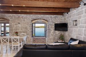 Apartman Sun 1 في شيبينيك: غرفة معيشة مع أريكة وجدار حجري +10 صور