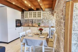 Apartman Sun 1 في شيبينيك: مطبخ وغرفة طعام مع طاولة وكراسي