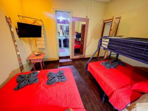 2 camas en una habitación con sábanas rojas y arcos negros en Calipso Bocastown B&B, en Bocas Town