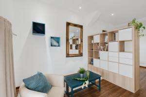 a living room with a mirror and a chair and a table at Casa Velella in Castellammare del Golfo