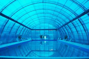 an indoor swimming pool with a glass ceiling at Pansionat Voskhod in Sergiyev Posad