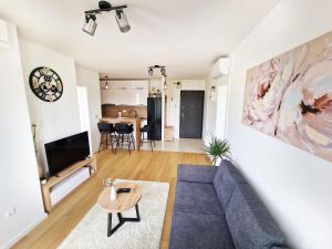 a living room with a blue couch and a table at Apartment Queen, self check-in, free private garage parking in Karlovac