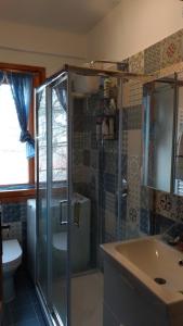 un bagno con doccia, lavandino e WC di La casetta di Rivisondoli a Rivisondoli