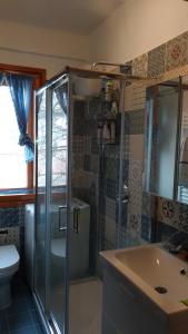 un bagno con doccia, lavandino e WC di La casetta di Rivisondoli a Rivisondoli