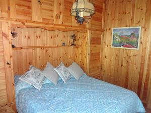 una camera con un letto in una baita di tronchi di La casetta di Rivisondoli a Rivisondoli