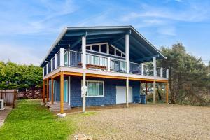 a blue house with a balcony on top of it at The Sand Ranch in Rockaway Beach