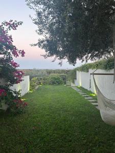 a yard with a hammock in the grass at Villa a schiera Ansedonia in Ansedónia