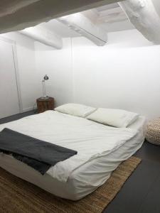 a bedroom with a white bed with a black blanket at Villa a schiera Ansedonia in Ansedónia