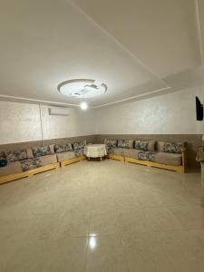 an empty room with couches and a table in a room at Moul Partma Saidia Mimi in Saidia 