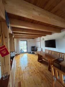 a large living room with a wooden table and a tv at Sklípek u Šebíka Popice in Popice