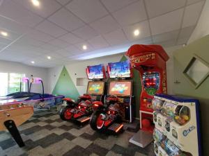 a gaming room with two arcade games and a motorcycle at LA PALMYRE LES MATHES Mobil home 3ch TOUT CONFORT 128 Camping 4 étoiles LES CHARMETTES in Les Mathes