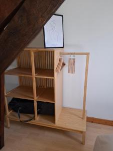 a wooden bookcase in a room with a shelf at L'étape du Theil in Le Theil-de-Bretagne