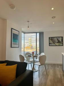 a living room with a couch and a table with chairs at Luxury 11th-Floor Penthouse - 2 Bed 1 Bath - City Centre Views - Gym & Netflix in Birmingham