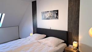 a bedroom with a bed and a picture on the wall at EL MIRADOR - Ferienwohnung Nähe Nürburgring - Eifel - Ahr - Rhein - RENOVIERT in Kempenich