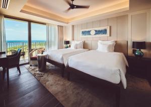a hotel room with two beds and a balcony at ANA InterContinental Ishigaki Resort by IHG in Ishigaki Island