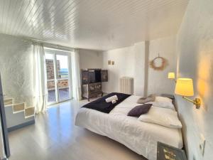 a bedroom with a large bed and a large window at Montpeyruvienne #Jardin#Parking in Montpeyroux