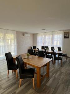 a conference room with wooden tables and black chairs at Apartment - Pension Marianna in Rust