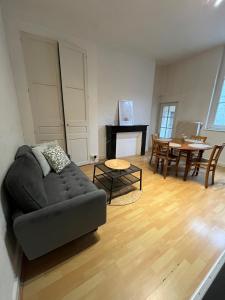 ein Wohnzimmer mit Sofa und Tisch in der Unterkunft Appartment Doutre-2e étage in Angers