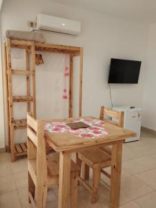 a room with a wooden table and chairs and a television at Tigre Center in Tigre