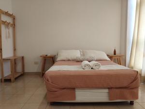 a bedroom with a bed with two towels on it at Tigre Center in Tigre