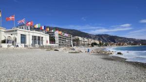 マントンにあるLes Rivages du Parcの旗と建物と海の海岸