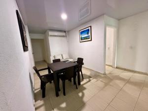 a dining room with a black table and chairs at Aparta Hotel Fama in San Andrés