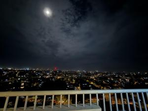 a view of a city at night with the moon at Modern 1BR Unit in Abreeza Place T2 with Pay Parking in Davao City