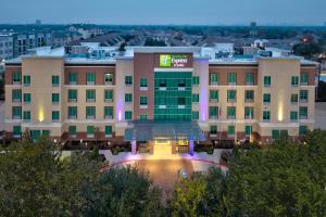 a large building with a fountain in front of it at Holiday Inn Express & Suites Houston S - Medical Ctr Area by IHG in Houston