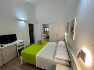 a bedroom with a bed and a desk and a television at La dimora dei Turchì in Otranto