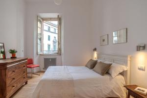 a white bedroom with a large bed and a dresser at Studio Caspani - Duomo Centro Storico in Como