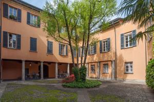 a large building with a tree in front of it at Studio Caspani - Duomo Centro Storico in Como