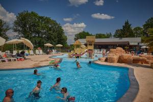 a group of people in a pool at a resort at Camping Le Chêne Gris in Pommeuse
