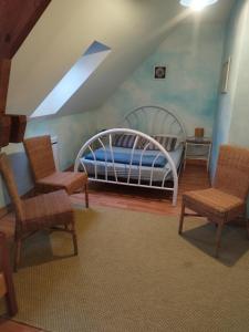 a bedroom with a bed and two chairs in it at Gite La Trotiniere in Luynes