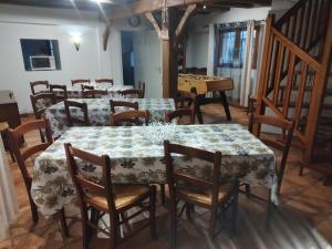 a dining room with a table and chairs and a piano at Gite La Trotiniere in Luynes