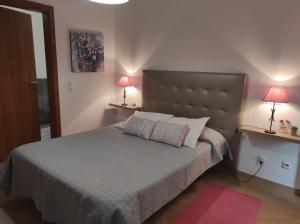 ein Schlafzimmer mit einem Bett mit zwei Lampen auf zwei Tischen in der Unterkunft Casa dos avós in Alvor