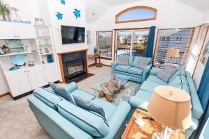 a living room with blue couches and a fireplace at Oceanside, Close to Beach, Hot Tub- OS5H, Long Beach Day in Corolla