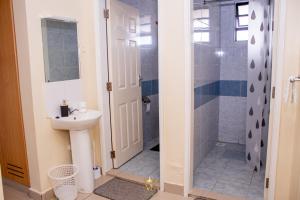 a bathroom with a sink and a shower at The Monarch Suites- Peaceful Luxe 2BR with view in Nakuru +18 photos