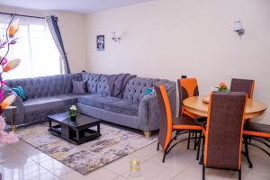 a living room with a couch and a table at The Monarch Suites- Peaceful Luxe 2BR with view in Nakuru