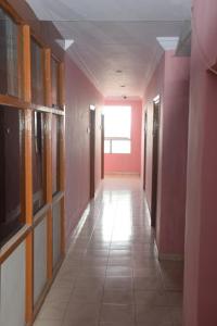 a hallway of a building with pink walls and a long hallway at Hotel Prashant International in Gandhidham