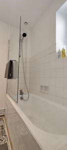 a bathroom with a shower with a white tub at Appartement 2 pièces aux pieds de la Cathédrale dans logis du 15ème siècle in Le Puy en Velay