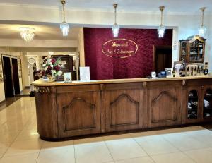 a restaurant with a wooden bar in a building at Dworek Nad Stawem & Łaźnia Piwna in Ostrów Mazowiecka