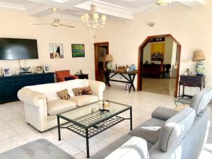 a living room with a couch and a table at Hibiscus WhiteHouse in Brufut