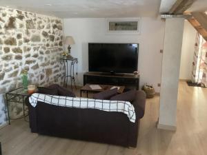 a living room with a couch and a flat screen tv at Maison charmante à Saint-Romain, animaux acceptés. in Saint-Romain
