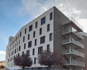 a large white building with a fire escape at Armonía y tranquilidad habitaciones in Albacete